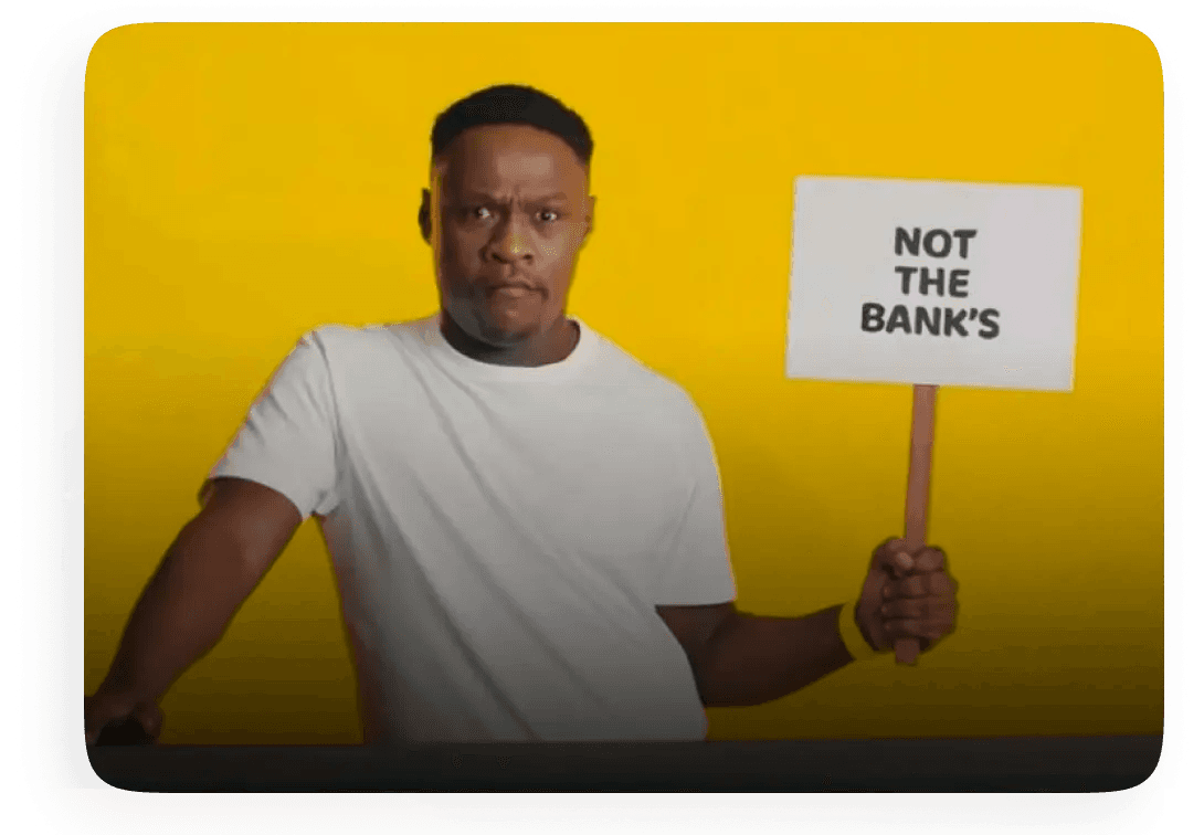 Man holding sign that says "Not the bank's"