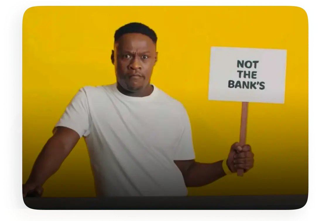 Man holding sign that says "Not the bank's"